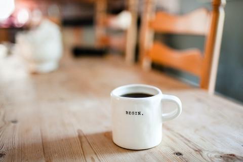 January 2021 photo writing prompt (word BEGIN on a white coffee mug sitting on a wooden kitchen table)