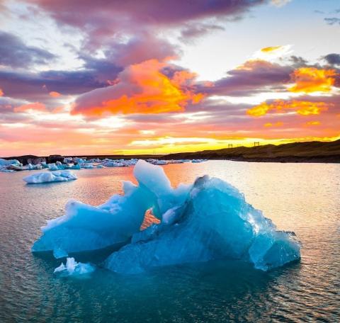 iceberg against backdrop of clouds and dawn sky_