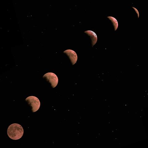 July 2022 photo writing prompt_black sky in space with an arching trajectory of a blood moon in various phases Photo by Karan Bhatia on Unsplash