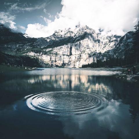 calm lake with large ripples in center with mountain and clouds in background by Fabio Comparelli via Unsplash Creative Commons license
