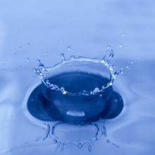 May 2022 photo writing prompt_closeup of a drop of water making a splash in a small blue body of water_Photo by Mulyadi on Unsplash