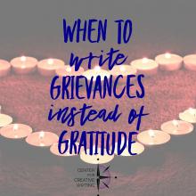 when to write grievances instead of gratitude blue text over lightened image of tea light candles arranged in the shape of a heart on red shag carpet via Unsplash