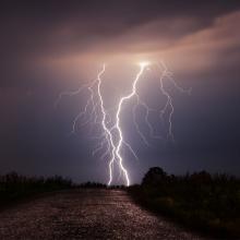 photo of twin lightning bolts striking simultaneously on a landscape via Canva
