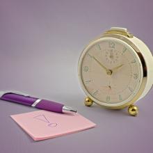 pink sticky pad purple pen and gold clock via canva