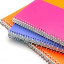 a stack of three spiral bound notebooks with orange blue and pink covers via Canva