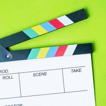 director's clapperboard on green surface via Canva